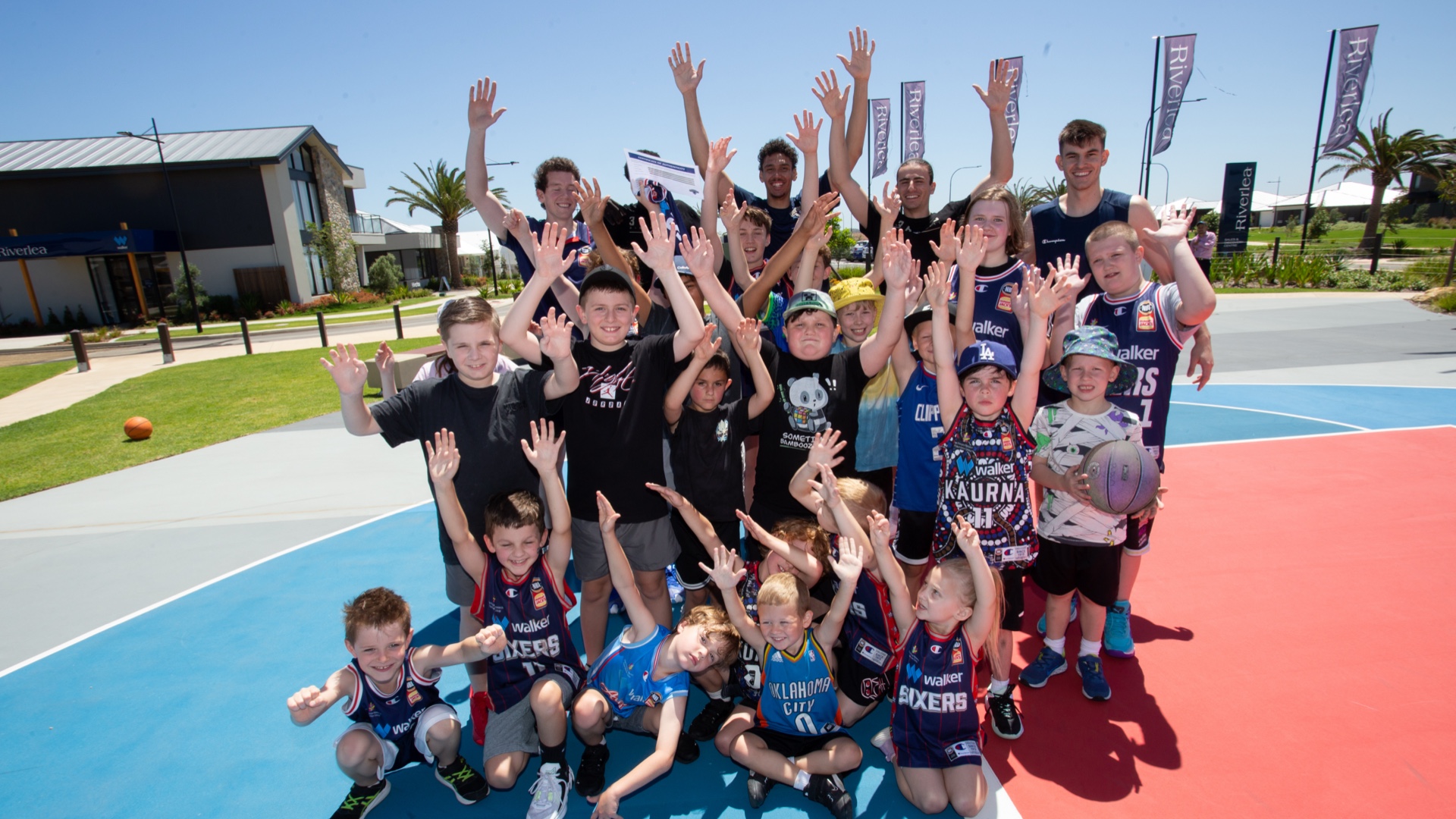 A group of young people posing for a photo on one of the basketball courts at Riverlea