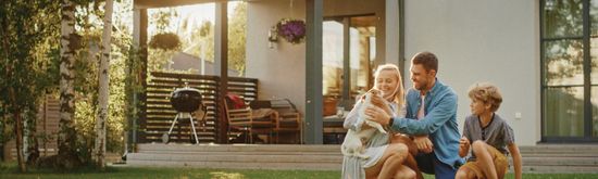 A family playing with their dog in a spacious backyard