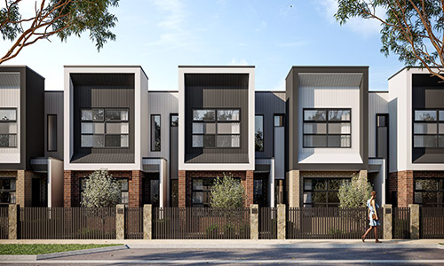 A row of modern townhomes at Riverlea along a quiet street on a bright, clear day.