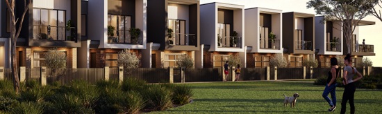 A row of modern townhomes at Riverlea along a quiet street on a sunny afteroon with people walking and standing with their dog.