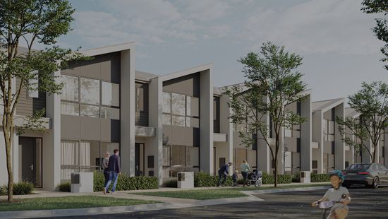 A row of modern townhomes at Riverlea along a quiet street on a bright, clear day.