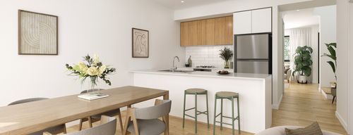 The modern kitchen and dining area of a townhome at Riverlea, showcasing a large kitchen countertop with breakfast bar stools facing over a long dining table.