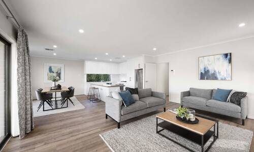 An artist’s impression of the inside of a modern living area in a house at Riverlea, with couches positioned around a TV area and a large dining table in the distance leading towards an open-plan kitchen with a large stone island.